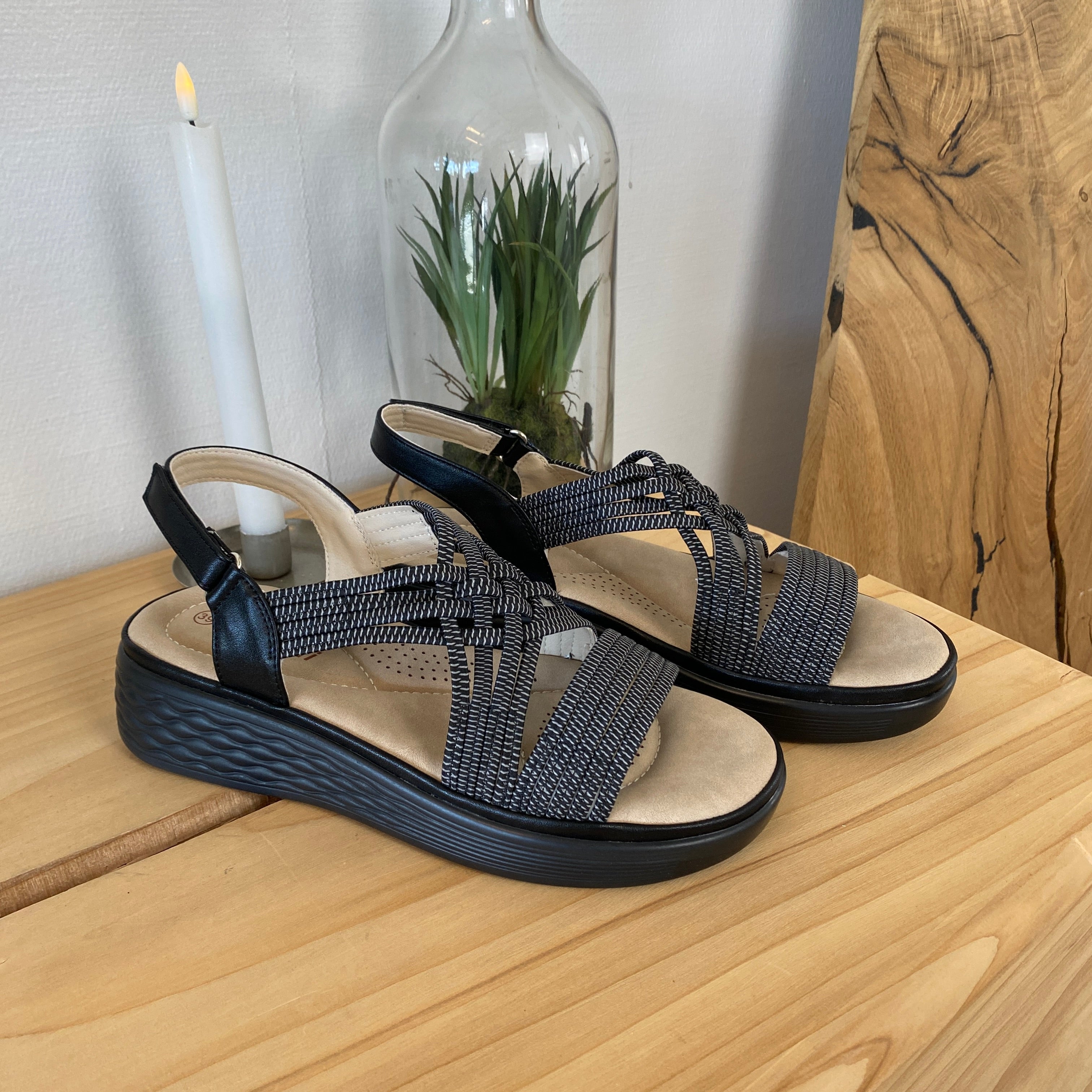 Svart sandal med elastiska remmar och stötdämpande sula