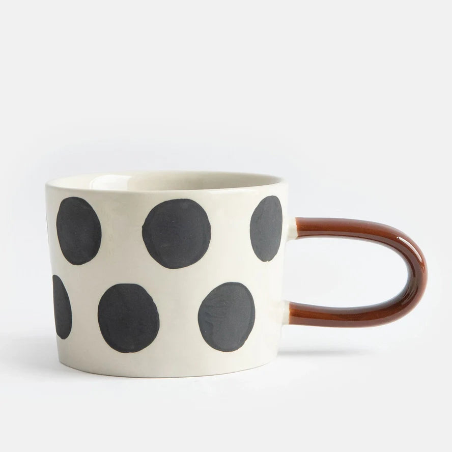 Mugg i stengods med stora svarta prickar och brunt handtag – modern kopp för kaffe och te
