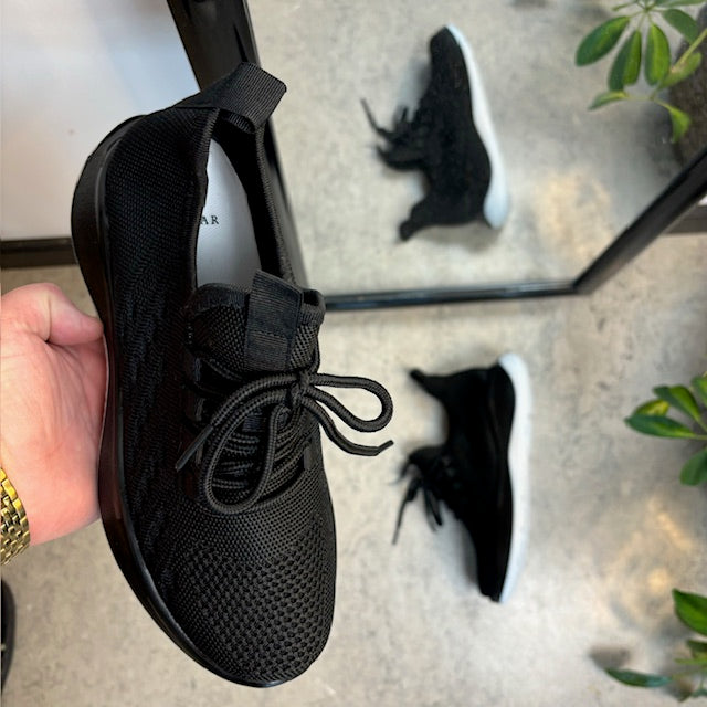 Svarta stickade slip-on-skor med fast kant vid öppningen