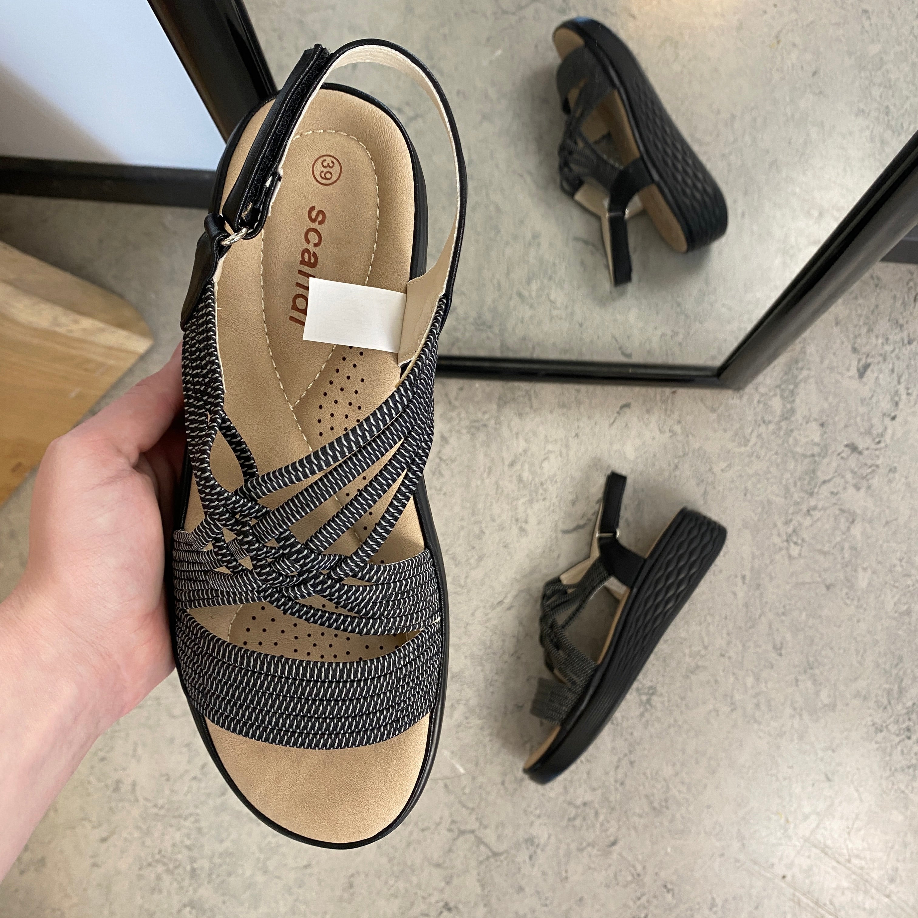 Svart sandal med elastiska remmar och stötdämpande sula
