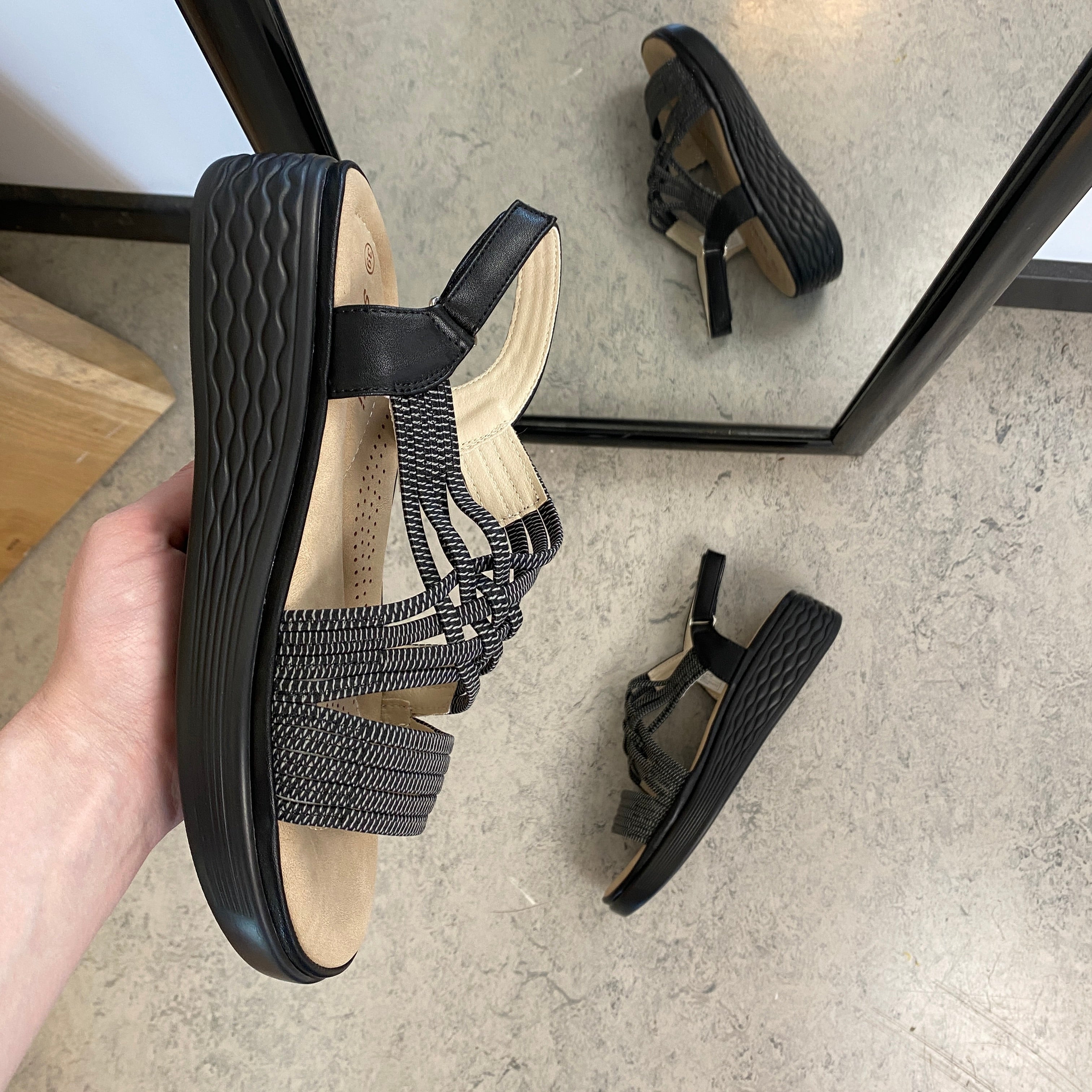 Svart sandal med elastiska remmar och stötdämpande sula