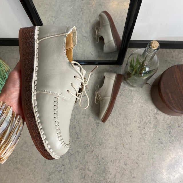 Beige snörade läderskor med bra stötdämpning.