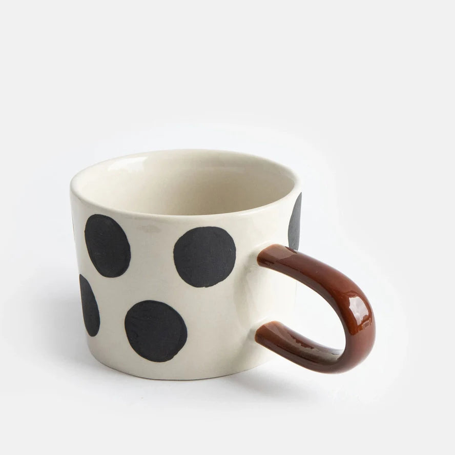 Mugg i stengods med stora svarta prickar och brunt handtag – modern kopp för kaffe och te