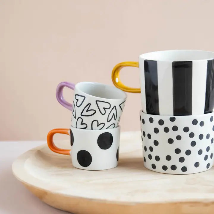 Mugg i stengods med stora svarta prickar och brunt handtag – modern kopp för kaffe och te