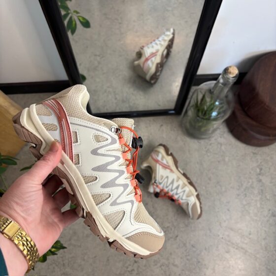 Flexibla beige sneakers med elastiska skosnören.