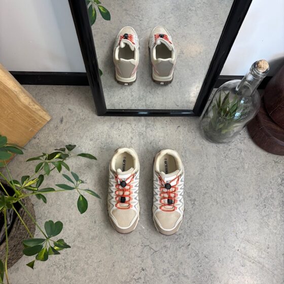 Flexibla beige sneakers med elastiska skosnören.